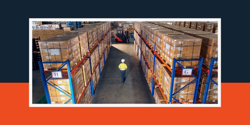 Warehouse manager walking down a warehouse isle looking for ways to improve storage space